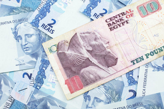 A close up image of an Egyptian ten pound bank note with Brazilian two reais bank notes in macro
