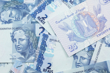 A close up image of an Egyptian twenty five piastres note with Brazilian two reais bank notes in macro