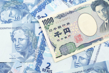 A one thousand Japanese yen bank note close up in macro with Brazilian two reais bank notes