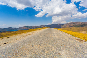 Cobbled road in the crater of Nemrut volcano, Bitlis Province, Eastern Turkey. Golden fields, hills...