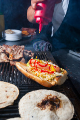 Hands of man preparing roasted bread wings fathoms on the street called Shuco in Guatemala, version of the Hot Dog