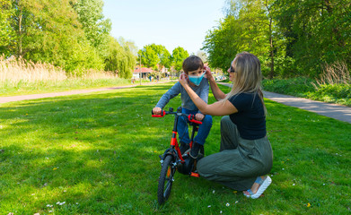 Mother and child in the open air wear facemask during coronavirus and flu outbreak.