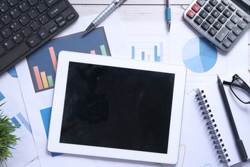 top view of digital tablet and financial chart in office desk