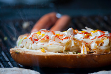 Fast food prepared on the street in Guatemala, Central America, bread with sausages, cabbage, avocado and sauces, called Shuco Chapina version of hot dog, danger of contagion of diseases and Covid 19.