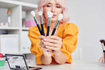 Woman with cosmetic brushes in hands
