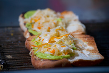 Fast food prepared on the street in Guatemala, Central America, bread with sausages, cabbage, avocado and sauces, called Shuco Chapina version of hot dog, danger of contagion of diseases and Covid 19.