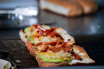 Fast food prepared on the street in Guatemala, Central America, bread with sausages, cabbage, avocado and sauces, called Shuco Chapina version of hot dog, danger of contagion of diseases and Covid 19.