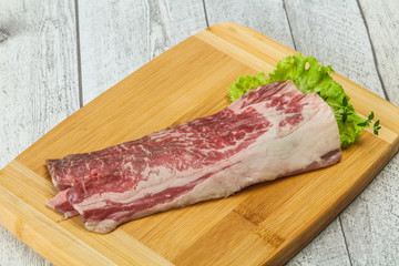 Raw beef bacon over wooden board