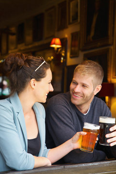 Happy couple drinking beer in pub