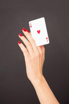 Portrait woman with red fingernails holding Ace of Hearts card