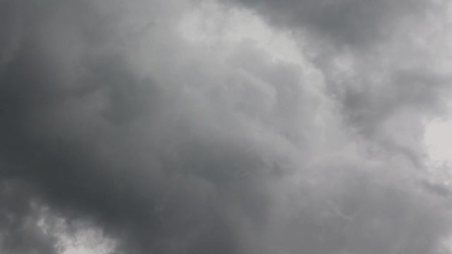 The sky is covered with gray clouds in anticipation of the rain. The clouds move fast. Between the gray clouds a gap is visible with white clouds lit by the sun
