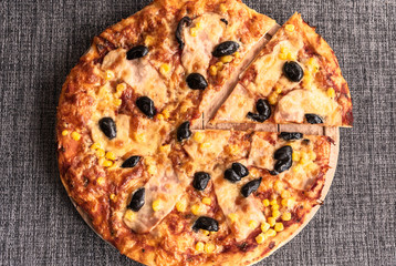 Delicious pizza surved on wooden plate.