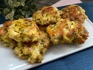 Chicken cutlets on a white plate, blue napkin on the table.