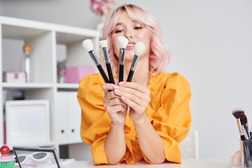 Woman with cosmetic brushes in hands