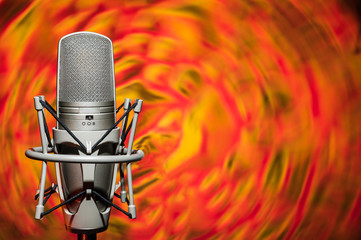 Professional, studio microphone on a background of a fiery rotating background. Located on the...