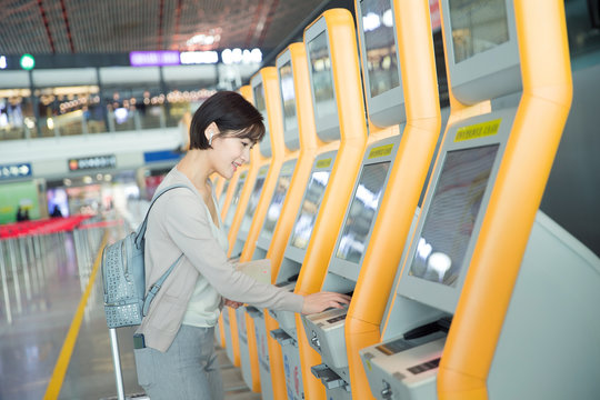 Business lady in the airport to use automatic machines