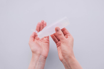 Woman disinfecting hands using sanitaser antiseptic gel.