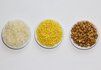 Set of colors food rice millet buckwheats on the plate on the white background