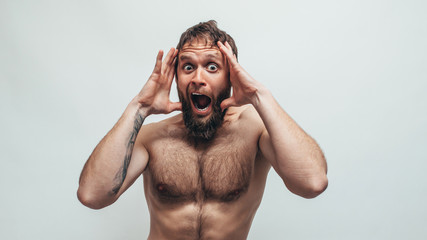 Amazed, excited handsome man with naked torso doesn`t believe his eyes. OMG. WOW!!! Discount, sale,...