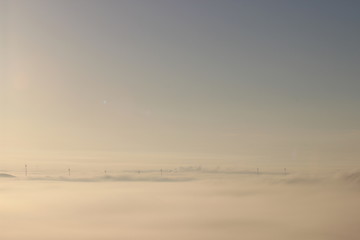 Fototapeta premium Windräder über dem Nebel