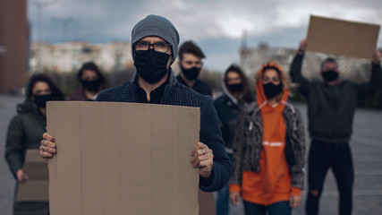 Diverse group of people protesting with blank sign. Protest against human rights, abuse of freedom...