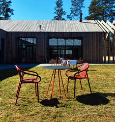 Picturesque view of tables and chairs on lawn at country complex