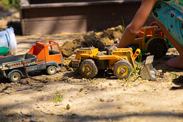 Kids on Playground playing in Sandbox with  digger