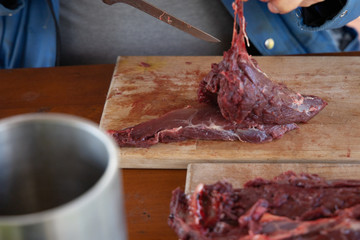 fresh deer cutted with knife on a wooden dish