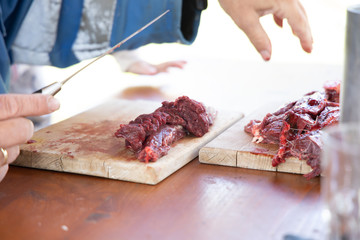 fresh deer cutted with knife on a wooden dish.