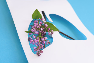 Concept paper lungs with flowers and leaves on the blue background. Coronavirus concept.