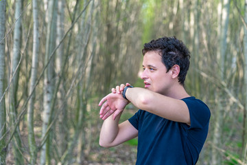 man speaks to smart watch when telephoning in nature