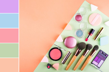 Make up accessories on orange cantaloupe and mint green background. Beauty products colorful...