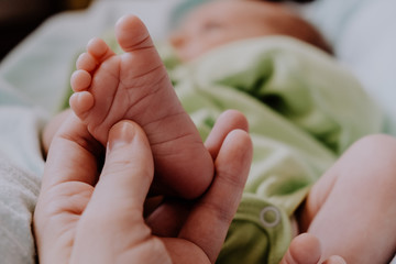 Massage of baby's feet. Mother's hand touching tiny newborn baby feet.