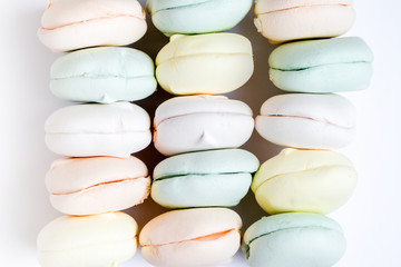 Air marshmallows in pastel shades on a white background. Gentle pastel colored zephyr in light key