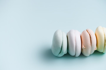 Air marshmallows in pastel shades on sky blue background. Gentle zephyr. close up, copy space