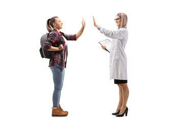 Fototapeta premium Female student gesturing high-five with a female doctor