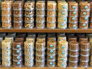 Shelf with rows of nuts stacked for sale. Stickers saying USDA organic. Individually packaged to...