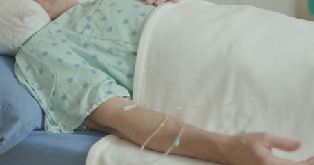 A senior adult male hospitalized with the coronavirus who is attached to a plasma drip in hopes of helping him fight off the disease.