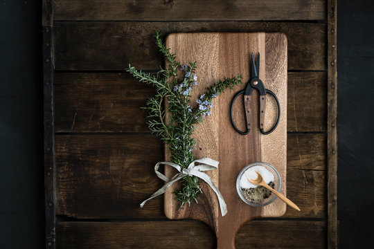bundle of fresh rosemary, coarse salt, scissors on cutting boards
