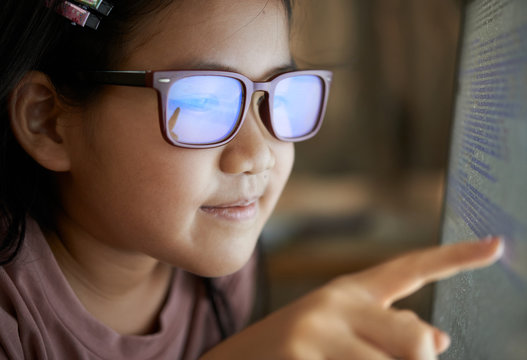Close-up view of a girl reading code on the monitor