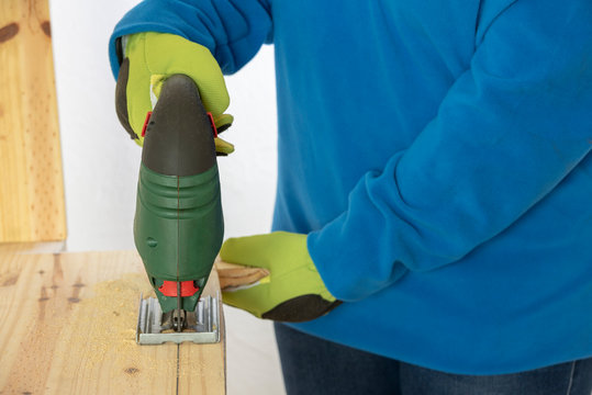 Una persona cortando madera con la sierra de calar