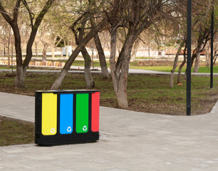 four waste sorting baskets on the city street for paper, plastic, glass and unsorted garbage