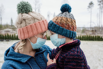 mother and son looking at each other with face masks for protection