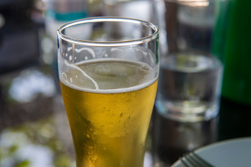 close up of glass of beer with glass of water in the background