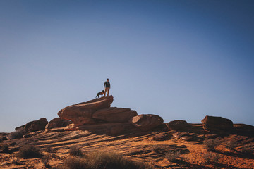 A man with a dog is standing near Horseshoe Bend, Arizona