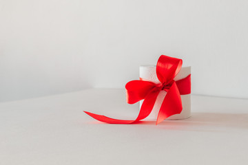 white toilet paper with a red bow on a white background.