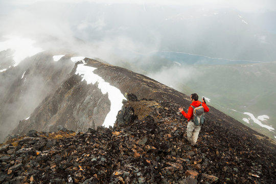 Man hikes down ridge on Cooper Mountain, Kenai Peninsula, Alaska