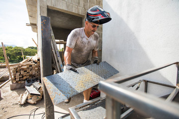 Man works on construction site, building staircase.