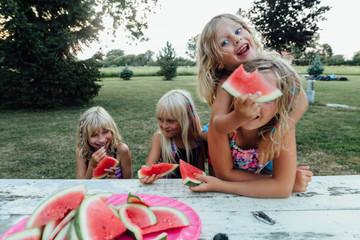 children being silly eating watermelon outside in the summer