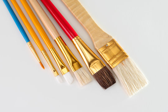 Different width paint brushes against white